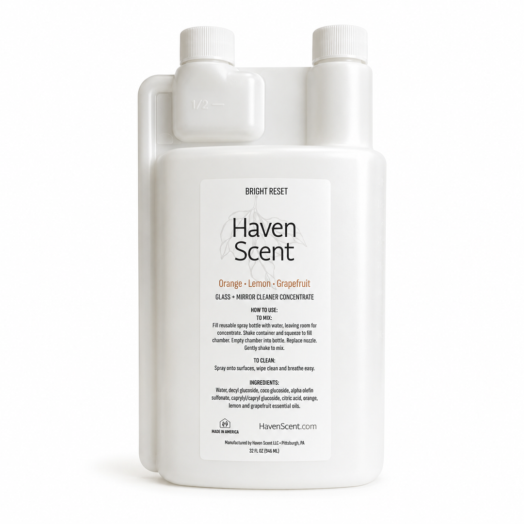 A white plastic bottle of Haven Scent Orange + Lemon + Grapefruit Glass & Mirror Cleaner Concentrate on a clean white background.